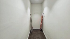 A narrow hallway with white walls and a dark floor, leading to a door at the end. - Golf Course Views Apt W Pool & Fast Wifi (Dubai)