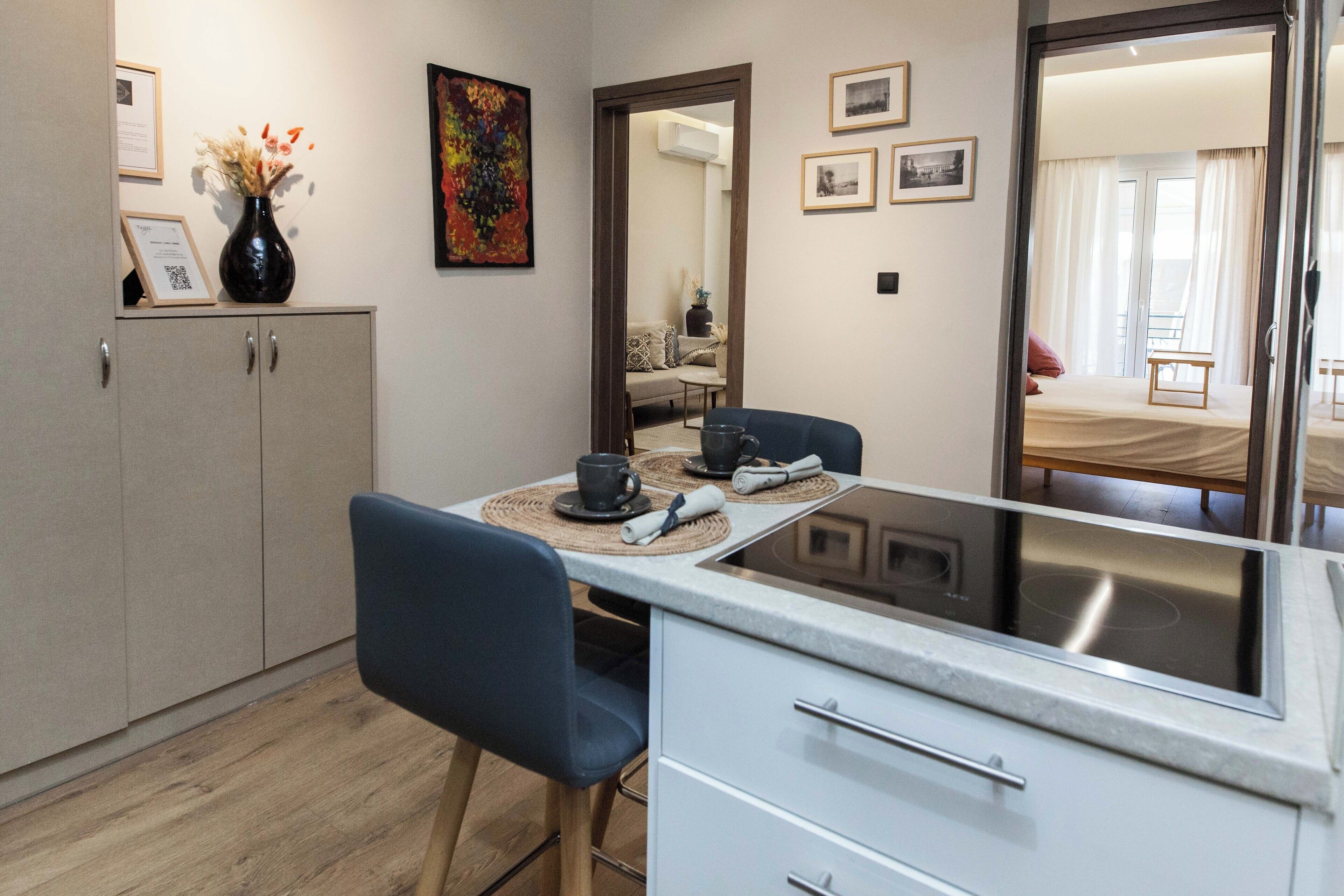 A modern kitchen with a dining table, chairs, and a cabinet.
