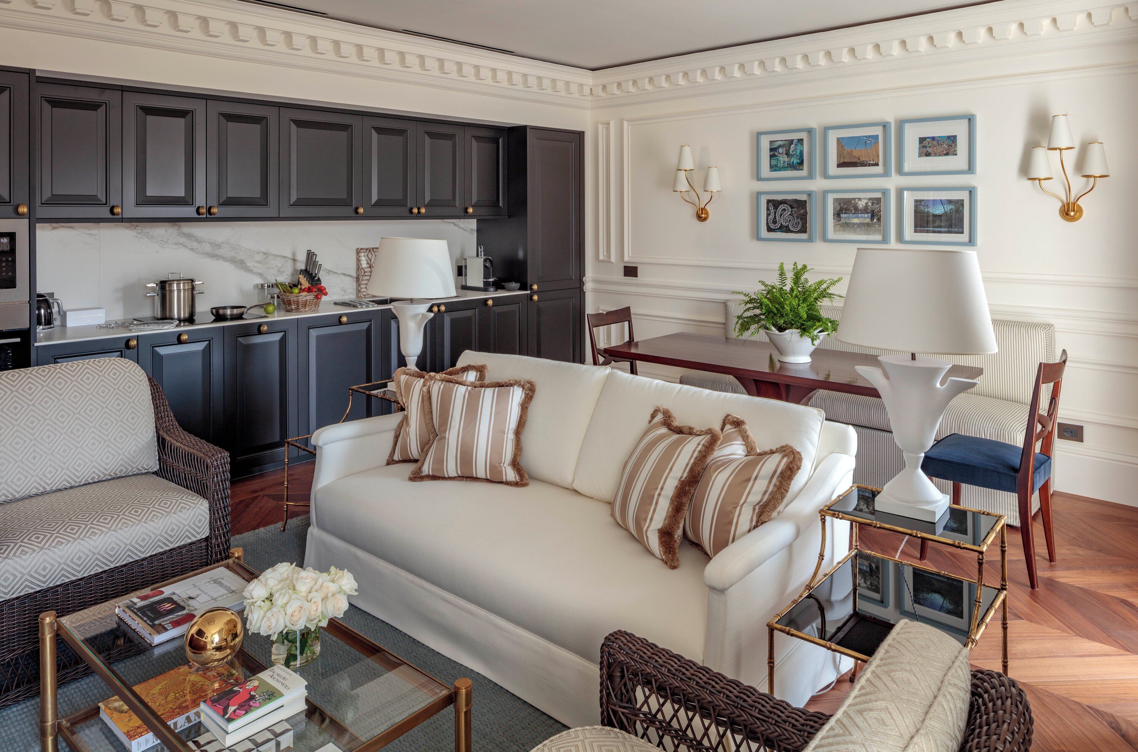 A modern living room with a white sofa, a coffee table, and a dining area with a table and chairs.