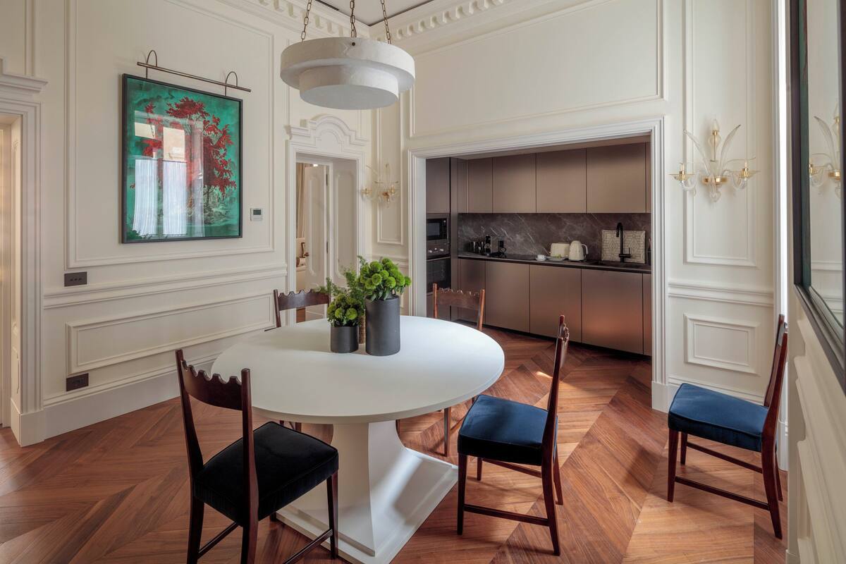 Un coin repas avec une table ronde, des chaises et une plante en pot.