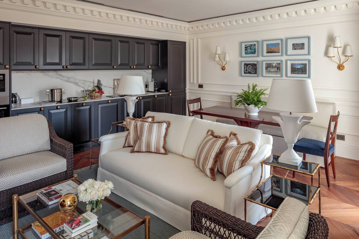 Un salon moderne avec un canapé blanc, une table basse et un coin repas comprenant une table et des chaises.