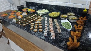 Ein Buffet mit verschiedenen Speisen, darunter Sushi, Salate und andere Vorspeisen.