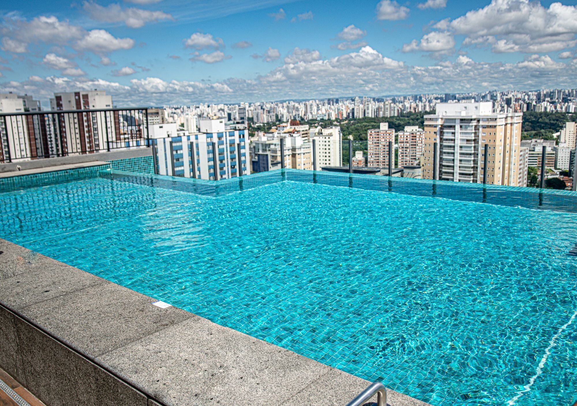Une piscine à débordement située sur le toit, offrant une vue panoramique sur la ville.