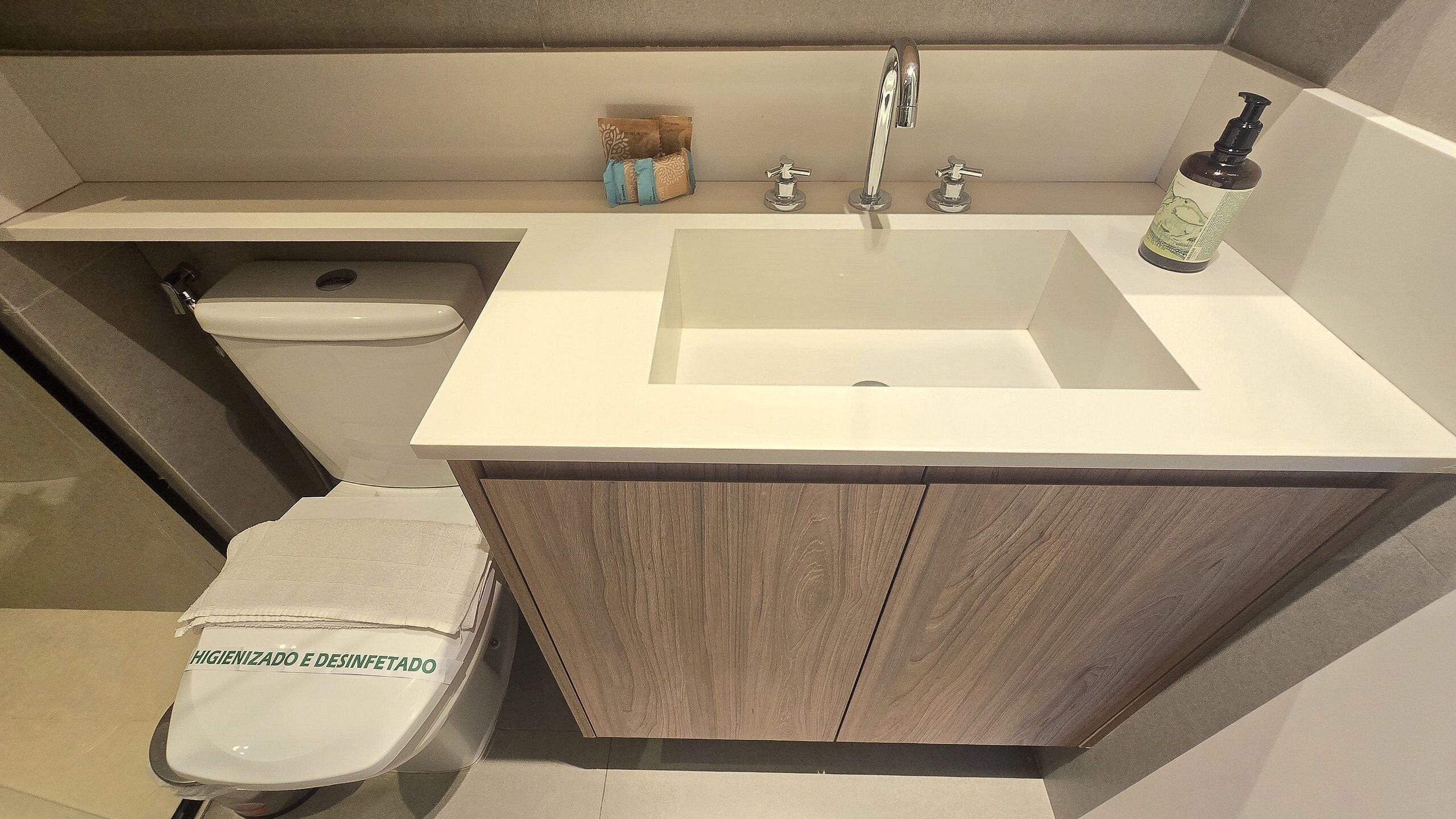 Une salle de bain comprenant un lavabo, des toilettes et un espace douche.