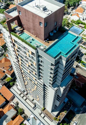 A high-rise building with a rooftop pool and a unique architectural design.