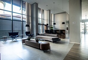 A spacious, modern living area with a curved sofa, a coffee table, and a blue chair.