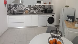 A compact kitchen with a microwave, toaster, and washing machine. - Casa Fonte do Meio Douro (Armamar)