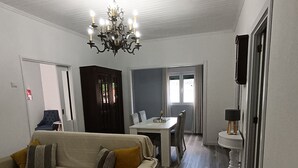 A living room with a sofa, a dining table, and a chandelier. - Casa Fonte do Meio Douro (Armamar)