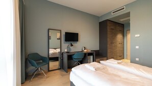 A modern hotel room with a bed, a desk, a chair, and a television. - A22 Hotel Gyál (Gyal)