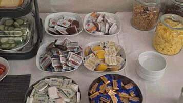 A table with various food items and containers, including jars of cereal and bowls of packaged goods.