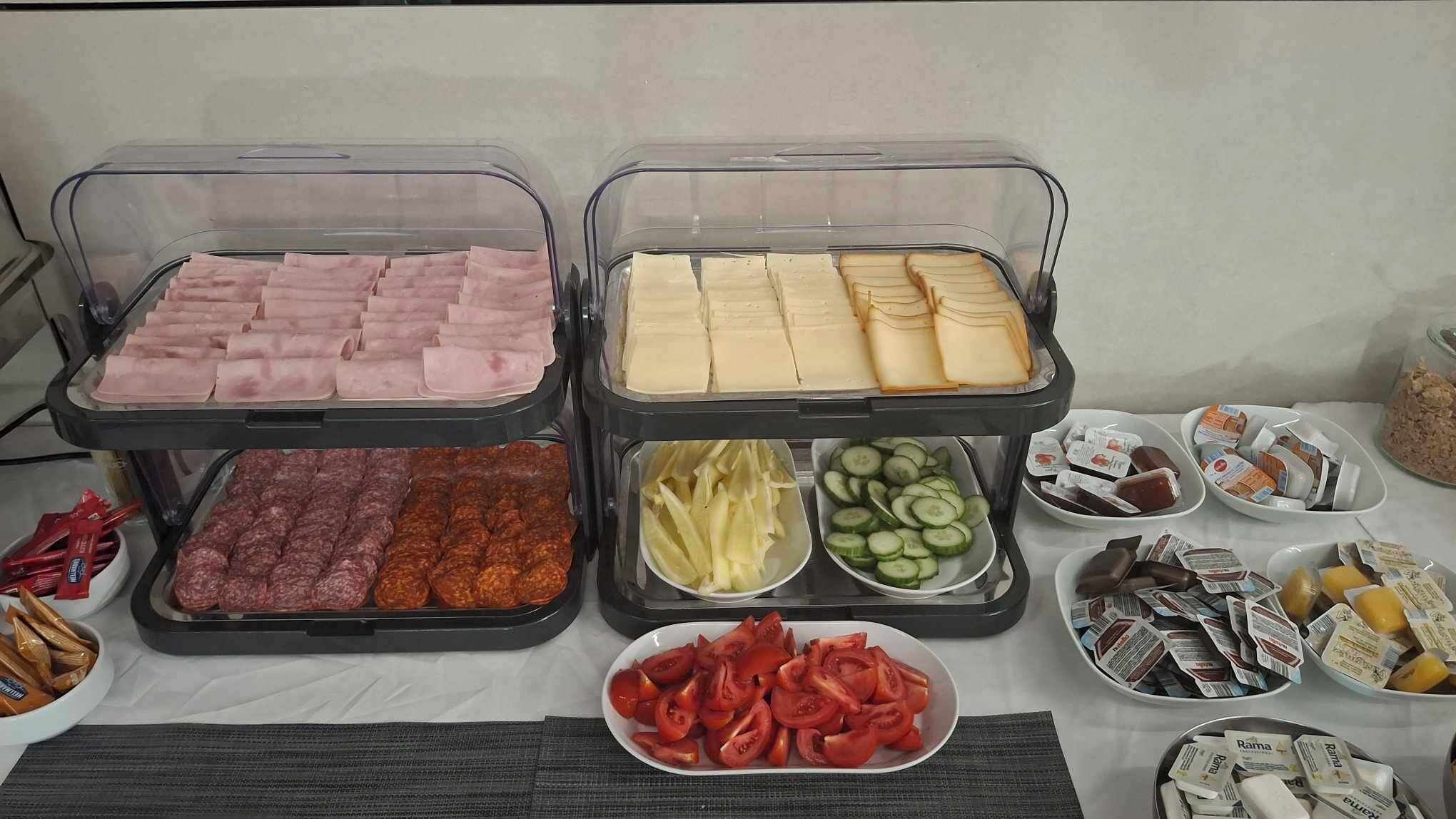 A buffet with various food items including meats, cheeses, and vegetables.