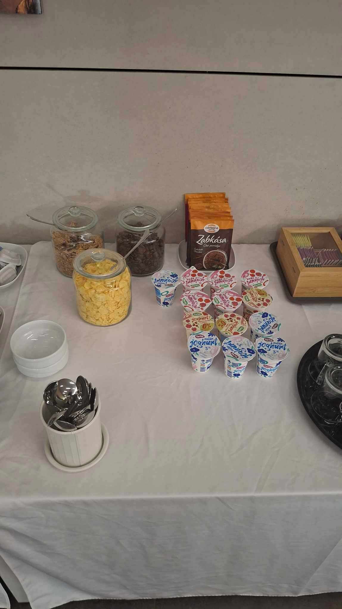 A table with various food items including jars of cereal, chocolate, and yogurt cups.