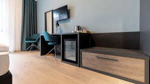A modern hotel room with a desk, chair, and a television mounted on the wall. - A22 Hotel Gyál (Gyal)
