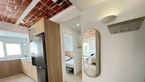 A modern kitchen with a black refrigerator, wooden cabinets, and a window. - Agi Arago 271 Apartamento for rent in Roses Girona. (Roses)