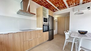 Cozinha moderna com armários de madeira, geladeira de aço inoxidável e forno embutido.
