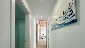 A hallway with a glass door, a painting on the wall, and a tiled floor. - Agi Arago 273 Apartamento for rent in Roses Girona. (Roses)