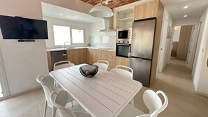 A modern kitchen with white cabinetry, a stainless steel refrigerator, and a built-in oven. - Agi Arago 273 Apartamento for rent in Roses Girona. (Roses)