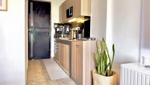 Une cuisine moderne avec des meubles en bois, un four encastré et un petit îlot central doté d’un évier.