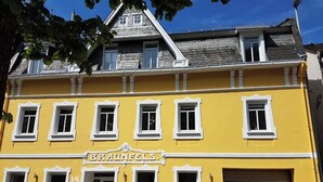 A yellow building with the sign "BRAUNFELS" and a garage door. - RankenNest (Bad Ems)