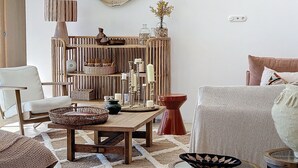 Una sala de estar acogedora con una estantería de madera, una mesa redonda y un sofá cómodo.