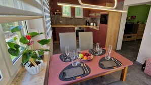A modern kitchen with a dining area set for four. - Haus am Wald Quietly located vacation apartment on the ground floor with terrace (Bad Tabarz)