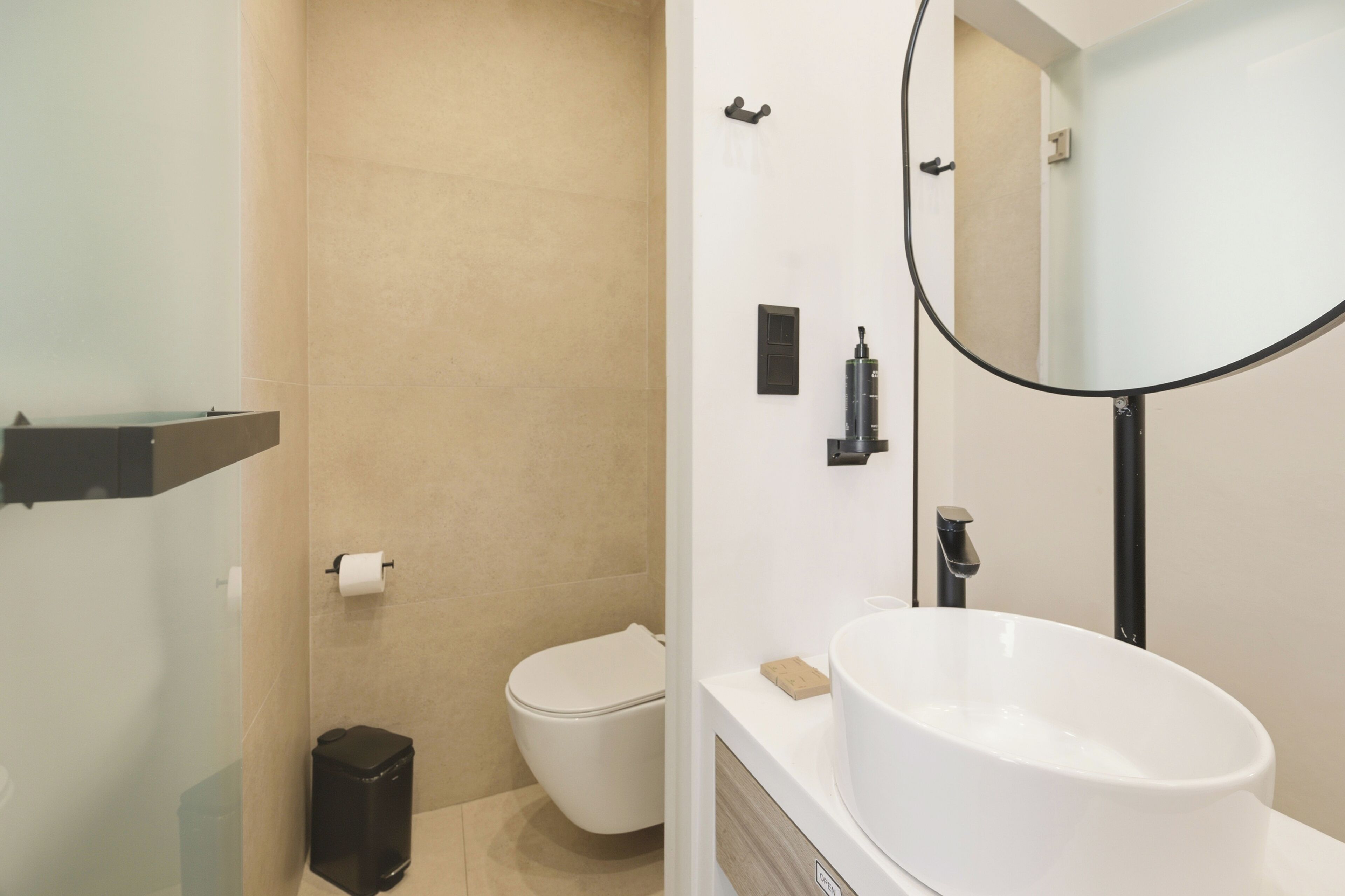 Ein modernes Badezimmer mit Toilette, Bidet und einem großen Waschbecken mit Spiegel.