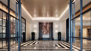 A modern lobby with a geometric floor pattern, large glass doors, and a central decorative wall. - Sofitel Shanghai North Bund (Shanghai)