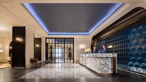 A hotel lobby with a reception desk, a patterned floor, and a blue accent wall. - Sofitel Shanghai North Bund (Shanghai)