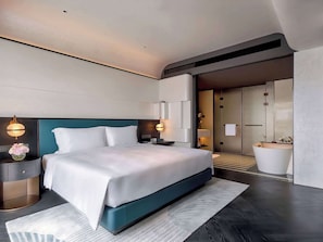Relax in a serene space with a large bed, bedside tables, and a wardrobe.