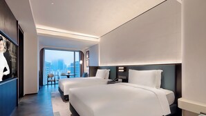 A modern hotel room with two beds, a desk, and a view of the city. - Sofitel Shanghai North Bund (Shanghai)