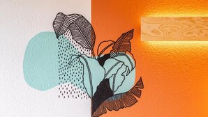 Pared con un diseño geométrico y una vista parcial de una habitación con piso estampado.