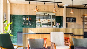 A bar area with wooden paneling, a counter with bottles, and seating with patterned cushions. - greet Brussels Airport Zaventem (Zaventem)