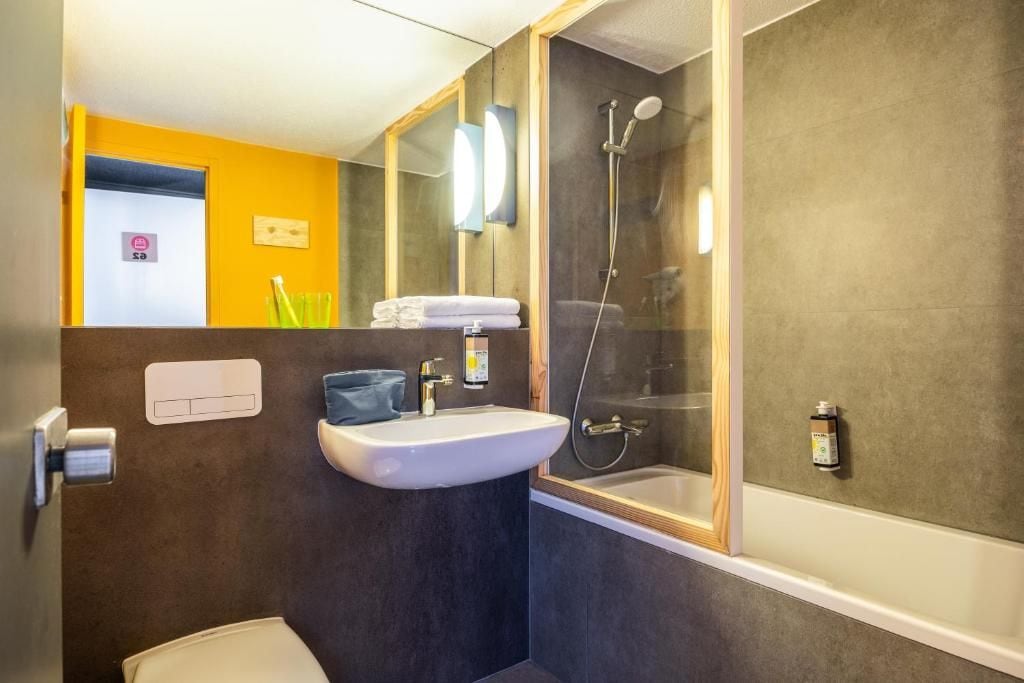 Une salle de bain avec un lavabo, des toilettes et une douche.