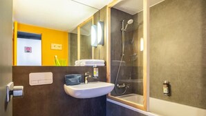 Un baño con lavamanos, inodoro y ducha.