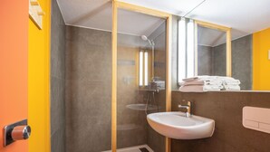 A modern bathroom with a glass-enclosed shower, a sink, and a mirror. - greet Brussels Airport Zaventem (Zaventem)