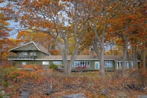 Een tweelaags huis met balkon, omringd door herfstkleuren.