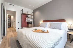 Une chambre moderne avec un grand lit, des tables de chevet, une armoire et une étagère.