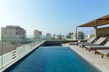 Una piscina al aire libre, sillones reclinables de piscina