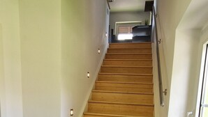 A wooden staircase with a handrail, leading to an upper floor. - Haus am Wald Ruhig Gelegene Ferienwohnung mit Großem Garten (Bad Tabarz)