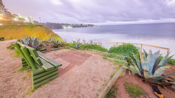 A coastal walkway with a wooden bench, a fence, and agave plants. - Oceana Suites Costa Quilen (Puchuncavi)