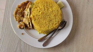 Two plates of yellow rice with vegetables and meat, served on white plates with silverware. - Hotel Stay Inn Dhaka (Dhaka)