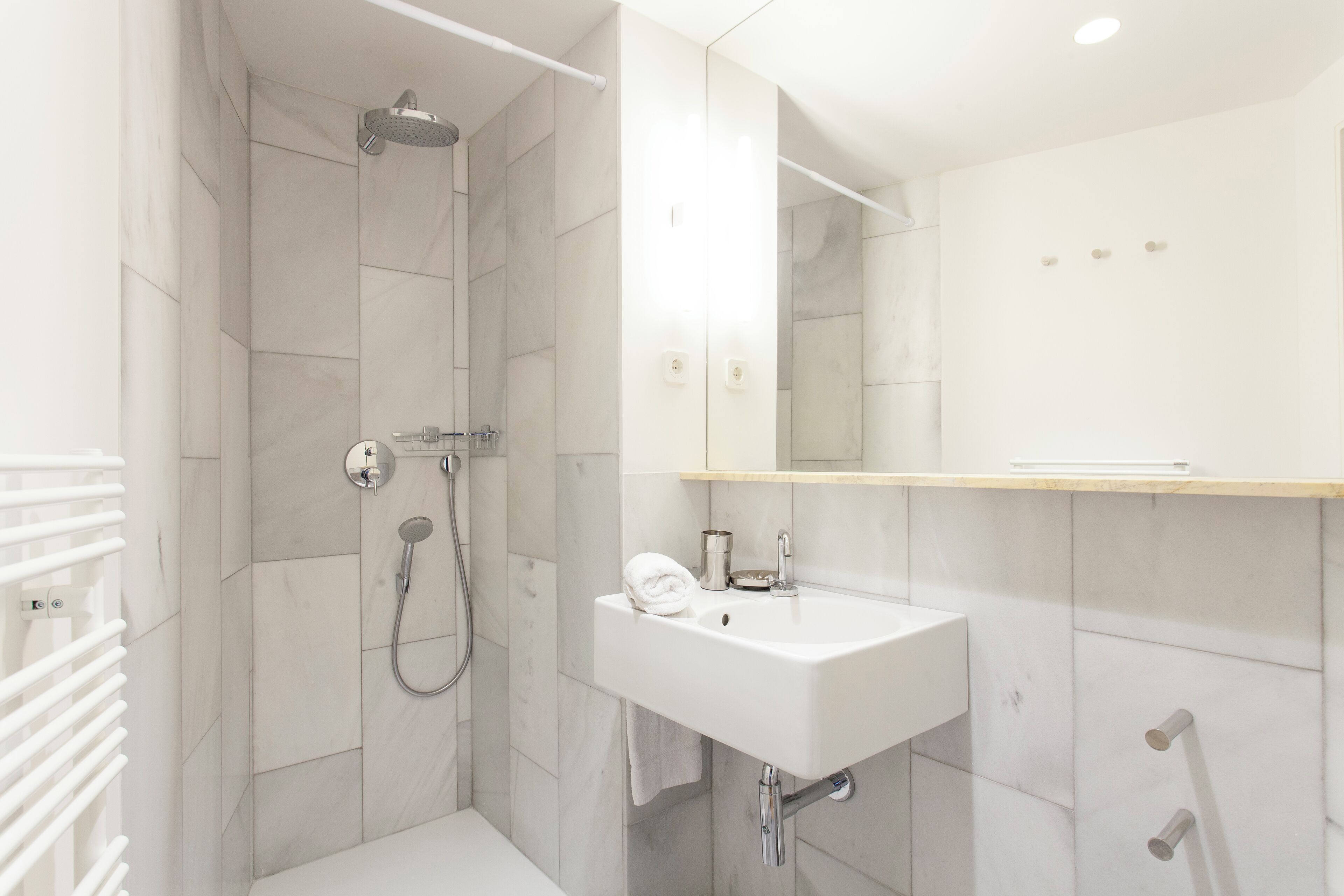 A modern bathroom with a shower, sink, and mirror.
