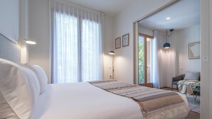 Habitación de hotel moderna con una cama grande, un escritorio y vistas al exterior.