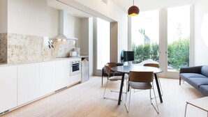 Una cocina moderna con comedor, ventanas amplias y vistas a zonas verdes.