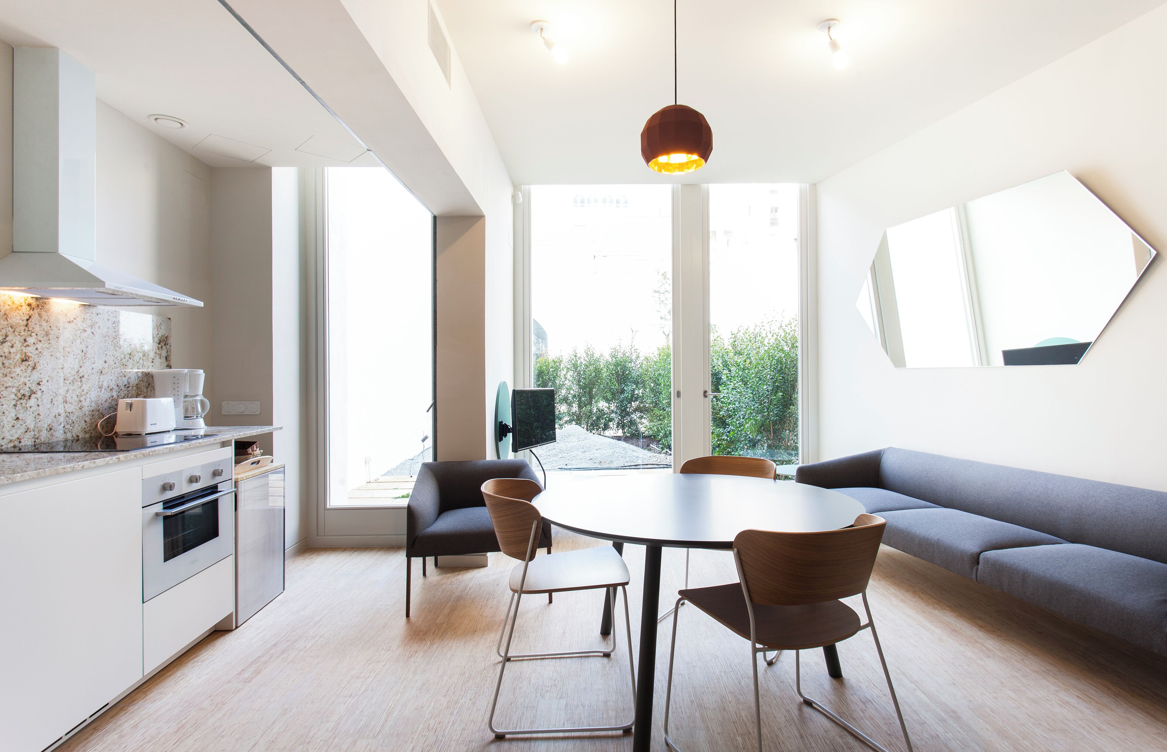 Cocina moderna con comedor, ventanas amplias y vista a zonas verdes.