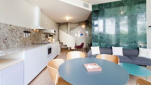 Una cocina moderna con encimeras de granito, horno empotrado y un comedor con mesa y sillas redondas.