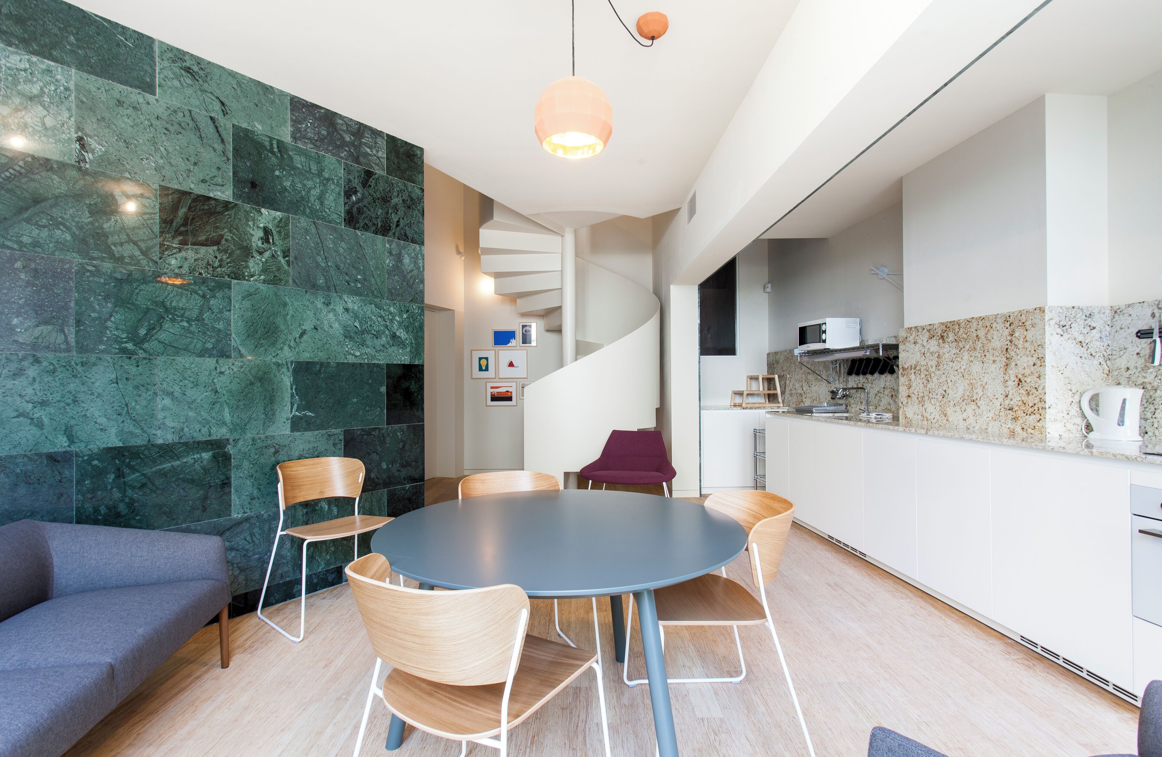 A modern kitchen with a white countertop, a built-in oven, and a microwave.