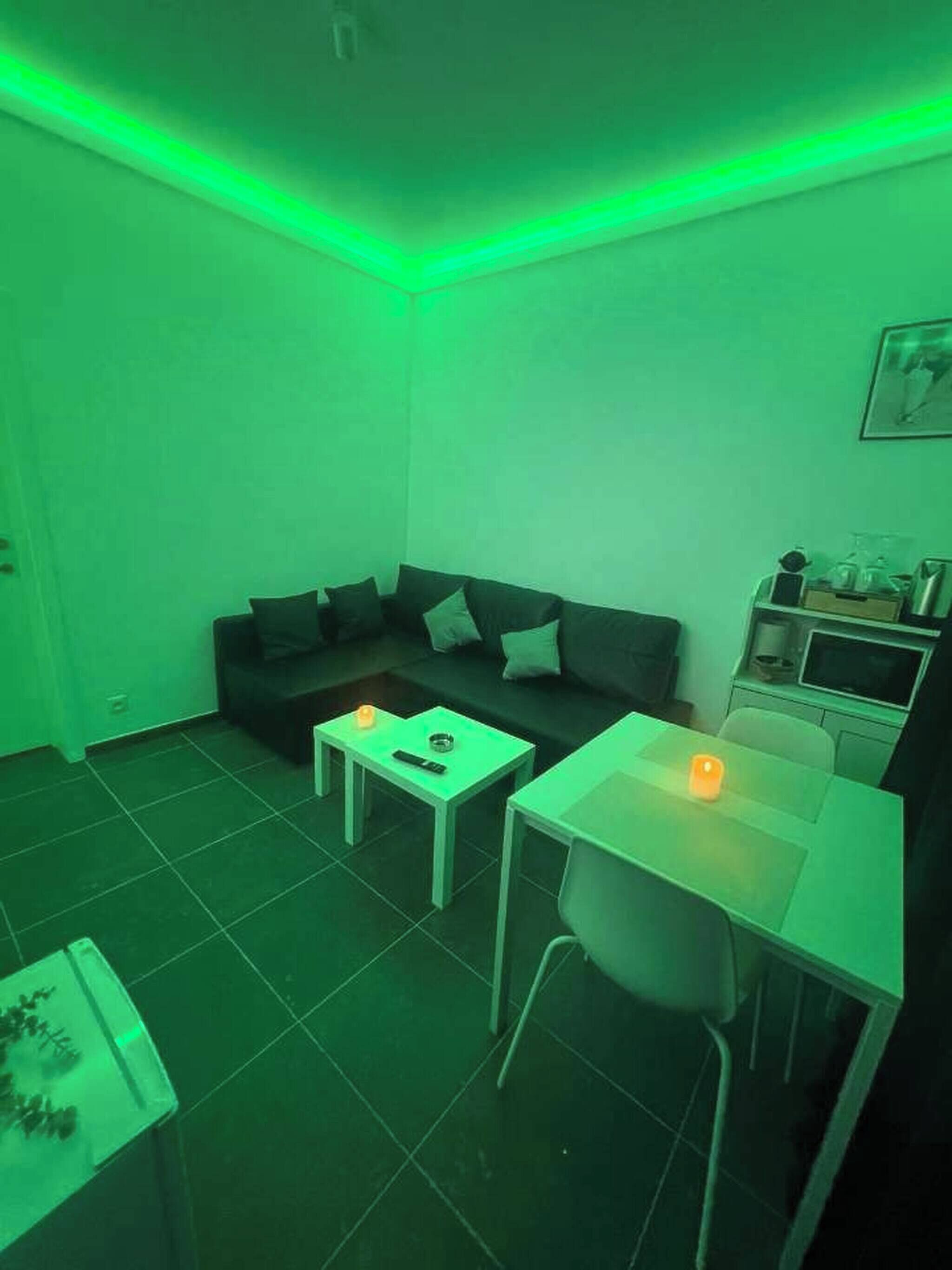 A small living area with a sofa, a coffee table, a dining table, and a TV.