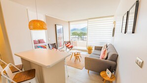 A modern living space with a kitchen, dining area, and seating area with a view. - Oceana Suites Papudo (Papudo)
