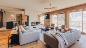 A modern living room with a sofa set, a coffee table, and a TV mounted on the wall. - Chalet La Belle Etoile (Montgenèvre)